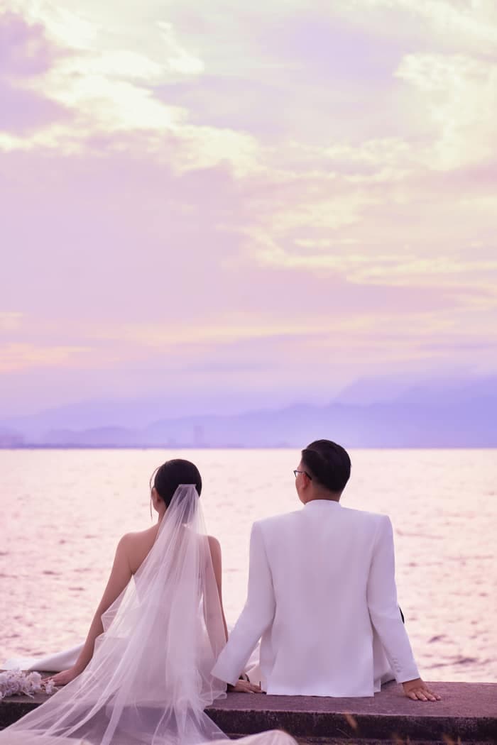 Bride and groom posing with a white classic car